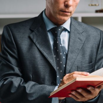 close-up-lawyer-reading-book-courtroom Şirketler ve Sözleşmeler
